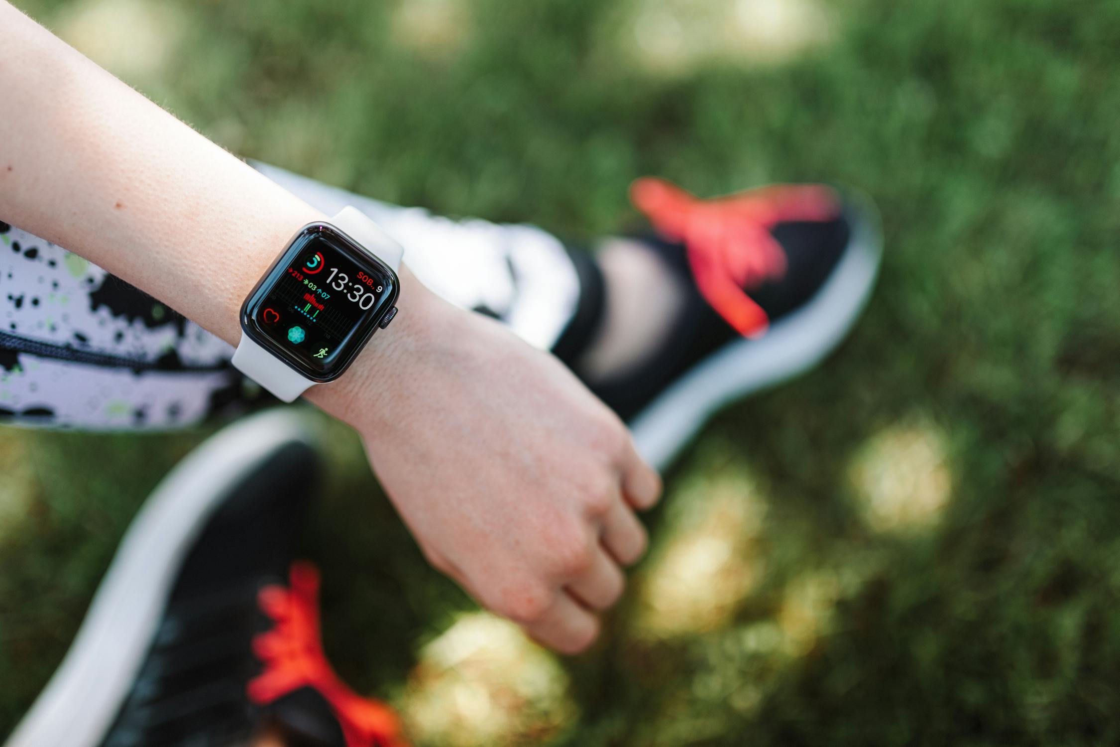 Person walking outdoors while checking their Apple Watch activity rings